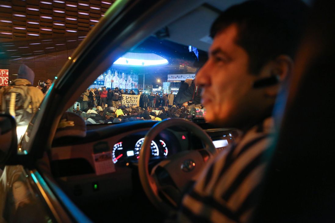 A cab driver seems more amused than annoyed at the fact that he was prevented from accessing Atlantic Avenue due to the protest and had to reverse down the street.<br>